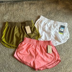 3 pairs of new with tags Nike running shorts, size medium.Pink,green,and white
